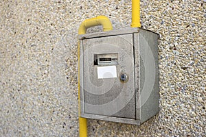 Close-up of metal steel gas meter box with connecting yellow pip