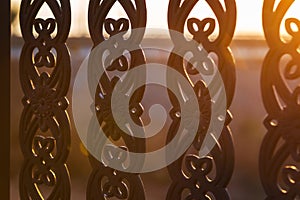 close up metal tracery fence at sunset time
