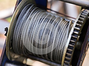 A close-up of a metal winch coil with steel cable wire on it