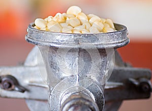 A close up from a metalic mill with some corn kernels