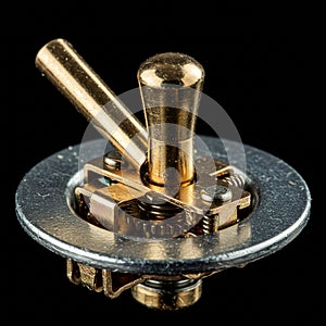 A close-up of a metallic toggle switch set against a black background. The switch