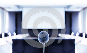 Close up microphone center of picture with screen projector background in meeting