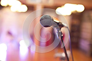 Close-up of a microphone in a concert hall on the background of blurred lights