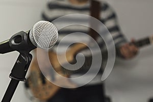 Close up of microphone in concert hall with blurred lights at background.