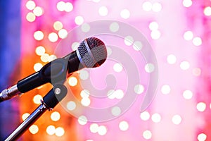 Close up of microphone in concert hall with blurred lights at background