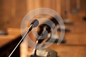 Close up on a microphone in a conference room of a municipal assembly. Other similar microphones can be seen in the background