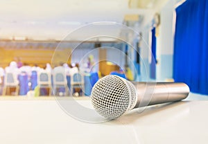 Close up microphone wireless Stand on white table in business conference interior seminar meeting room and Background blur