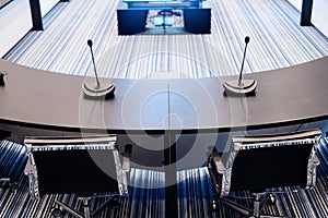 Close-up of microphones in an empty meeting room at a press conference.