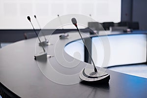 Close-up of microphones in an empty meeting room at a press conference.