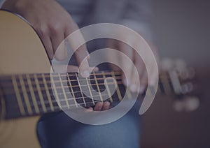 Close up of mid section of a person playing a guitar