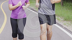 Close up middle aged couple jogging and running together at the park