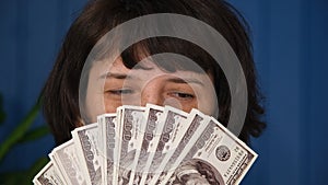 Close up Middle aged woman holding in hands money cash dollars. Woman showing dollar banknotes. American cash money in