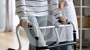 Close up middle aged woman holding hands on walking frame.