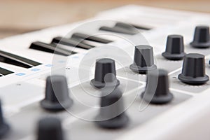 Close up of MIDI controller volume fader, knob and keys