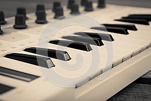 Close up of MIDI controller volume fader, knob and keys.