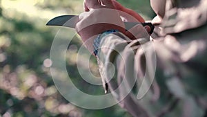 Close up of military sharpen knife with bilestone in the forest