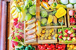 Close up Miniature clay figurine Thailand`s floating market,Miniature boat carrying tropical fruit on wood background