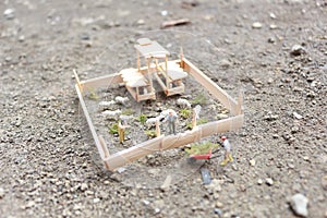 A close up of miniature figure of a goat herder feeding in a wooden cage.