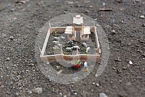 A close up of miniature figure of a goat herder feeding in a wooden cage.