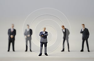 Close-up of miniature figure of one businessman standing out from the crown of others businessmen , Leadership concept