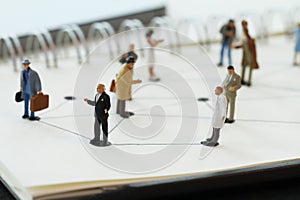 Close up of miniature people with social network diagram