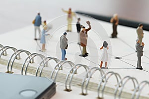 close up of miniature people with social network diagram on open