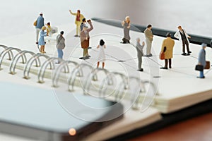 close up of miniature people with social network diagram on open