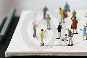 close up of miniature people with social network diagram on open