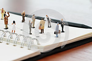 close up of miniature people with social network diagram on open