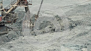 Close-up of mining excavator scooped up the ore with a bucket. Quarry mining equipment.