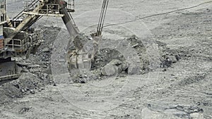 Close-up of mining excavator scooped up the ore with a bucket. Quarry mining equipment.