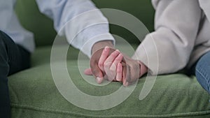 Close up of Mixed Race Couple Holding Hands on Sofa