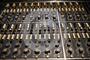 Close-up of mixing console panel in sound recording studio