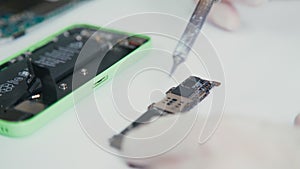 Close-up of mobile phone parts brazing. Services on repair of phones.