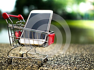 Close up the mobile phone in shopping cart, business in eCommerce concept