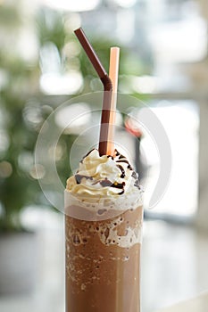 Close up of mocha coffee with whiped cream and nature bokeh background. photo
