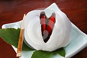 Close up mochi candy dessert with slices of strawberry and sweet mashed taro on wooden background