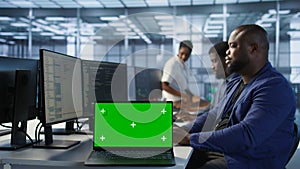 Close up of mockup notebook on desk next to workers coding in data center photo