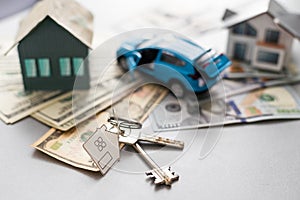 Close up of model house and car, money on white table. Real estate, home loan and investments concept