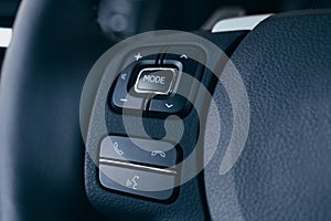 Audio control buttons on the steering wheel of a modern car