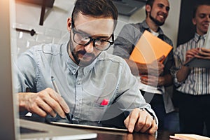 Close-up of a modern businessman using tablet computer to work w