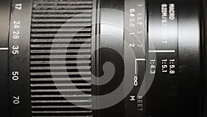 Close-up of a modern camera lens, turning of a zoom rings in shallow depth of field