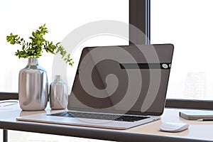 Close up of modern designer office desktop with black mock up computer monitor, reflections, decorative vase with plant, other
