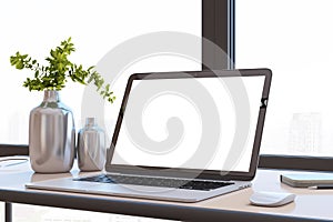 Close up of modern designer office desktop with white mock up computer screen, decorative vase with plant, other objects and