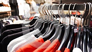 Close-up Modern fashionable women`s clothing hangs on black plastic hangers in a department store of a clothing store. Online