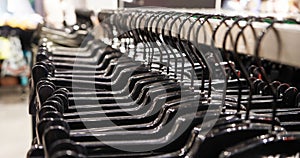 Close-up Modern fashionable women`s clothing hangs on black plastic hangers in a department store of a clothing store. Online