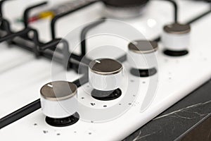 Close-up of modern gas stove flame control knobs.