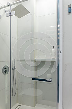 Close up modern glass shower in the white ceramic bath room