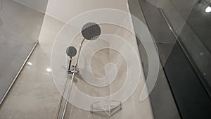 Close up modern glass shower in white ceramic bathroom. Luxury hotel bathroom interior with glass shower. Transparent