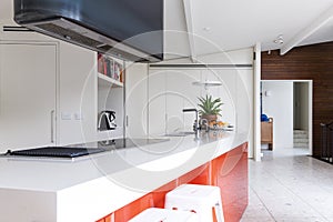 Close up of modern kitchen island bench with orange accent color